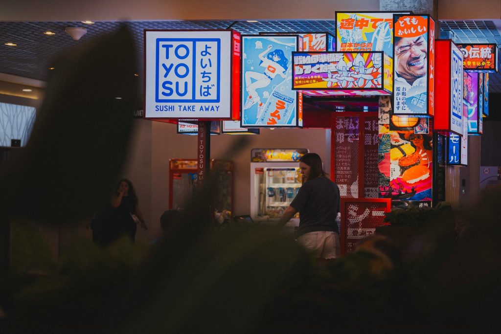 Bright japanese signs illuminate a bustling city street at night.