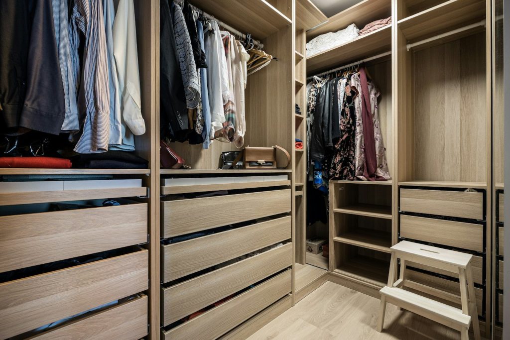 A walk in closet filled with lots of clothes